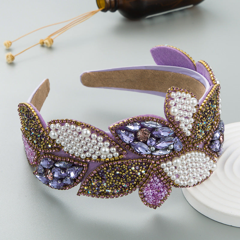 Wide pearl and rhinestone headband with purple center stones and gold-green sparkle