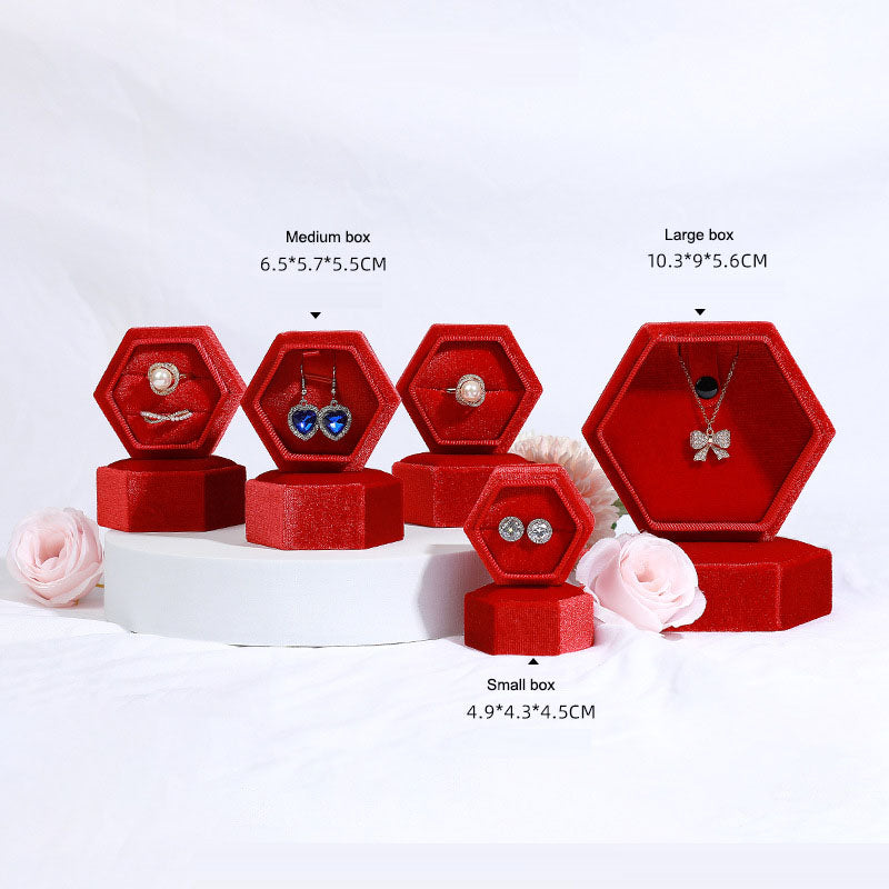 Hexagonal velvet jewelry box set in red, multiple hex shapes displaying ring and pendant jewelry