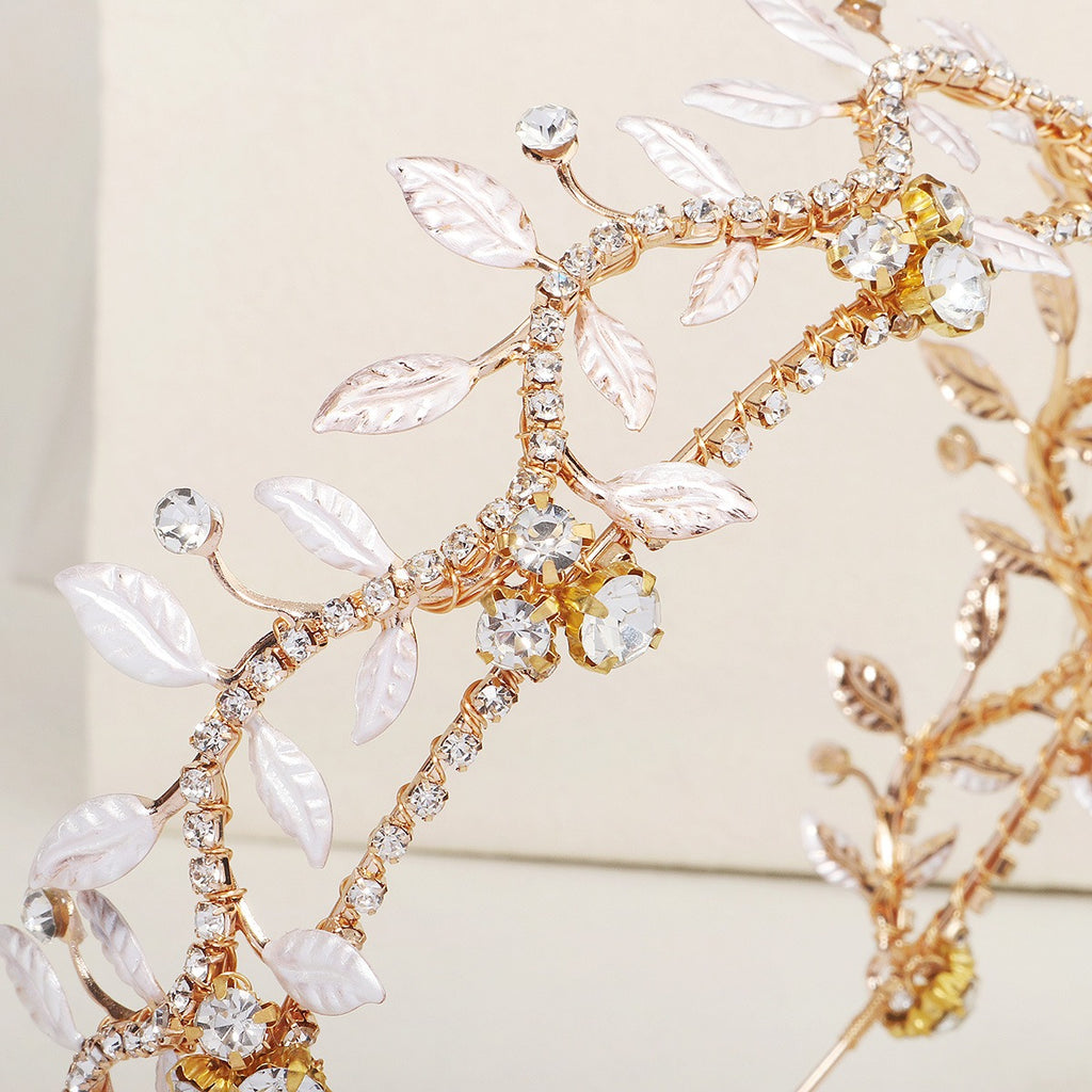Close-up gold rhinestone leaf headband with silver leaf charms and crystal accents