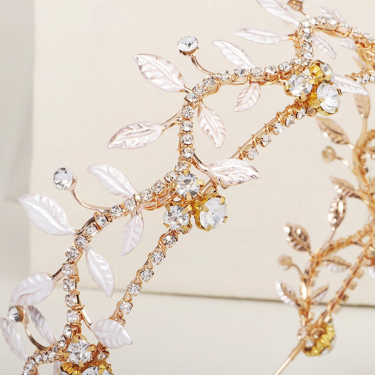 Close-up gold rhinestone leaf headband with silver leaf charms and crystal accents