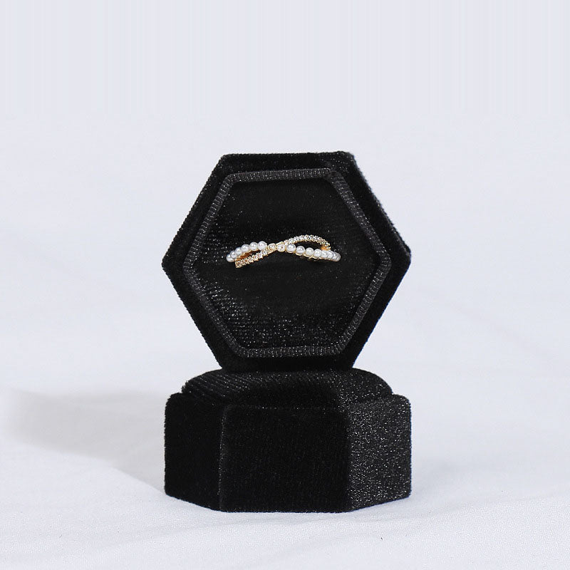 Hexagonal velvet jewelry box in black with a bracelet necklace displayed inside