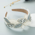 Wide white pearl and rhinestone headband with clear crystal center and bow leaves