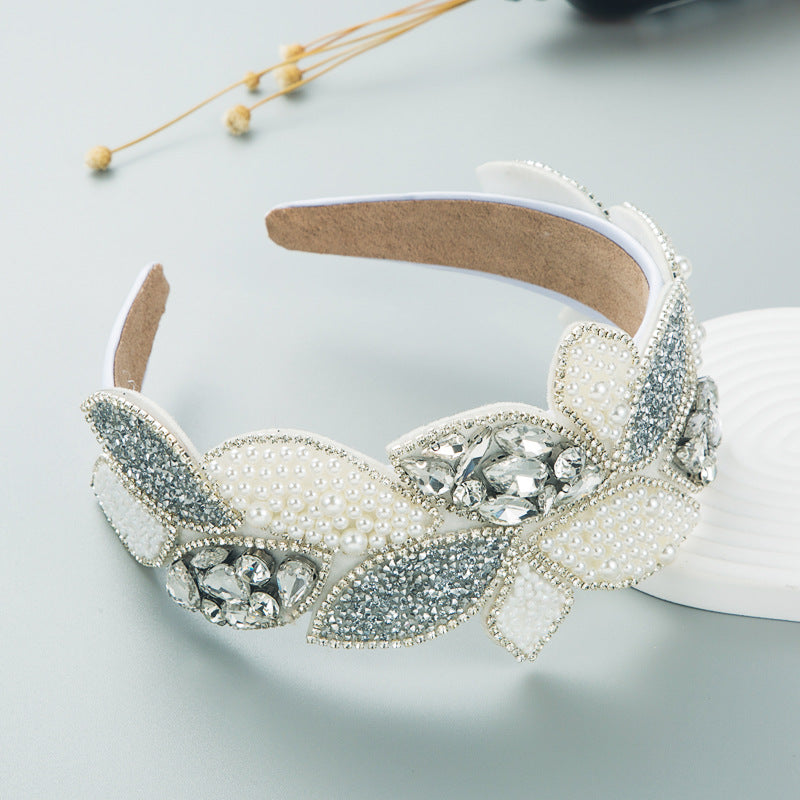 Wide white pearl and rhinestone headband with clear crystal center and bow leaves