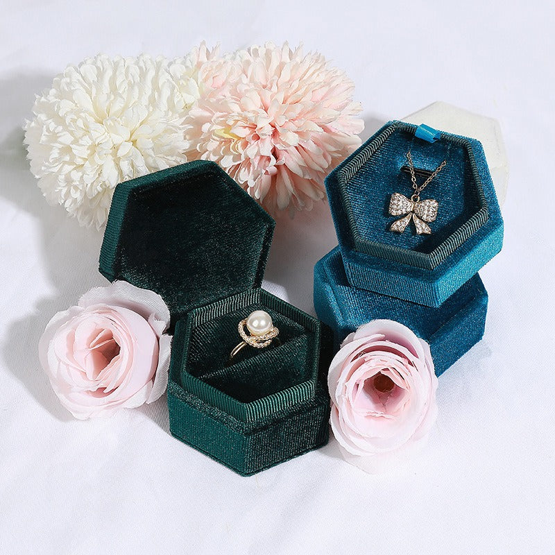 Hexagonal velvet jewelry box set with dark teal and green fabric, showing ring and pendant pieces