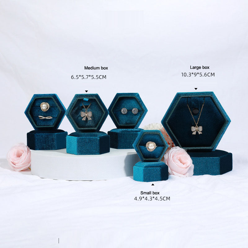 Hexagonal velvet jewelry box set in teal blue with multiple hex compartments for rings and pendants
