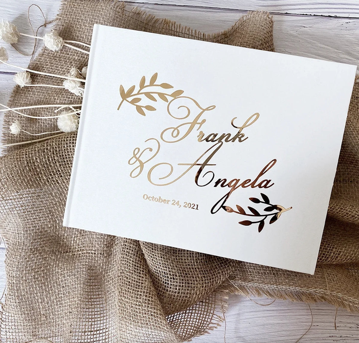 Personalized wedding guest book with gold script "Hank + Angela" and Oct 28, 2021