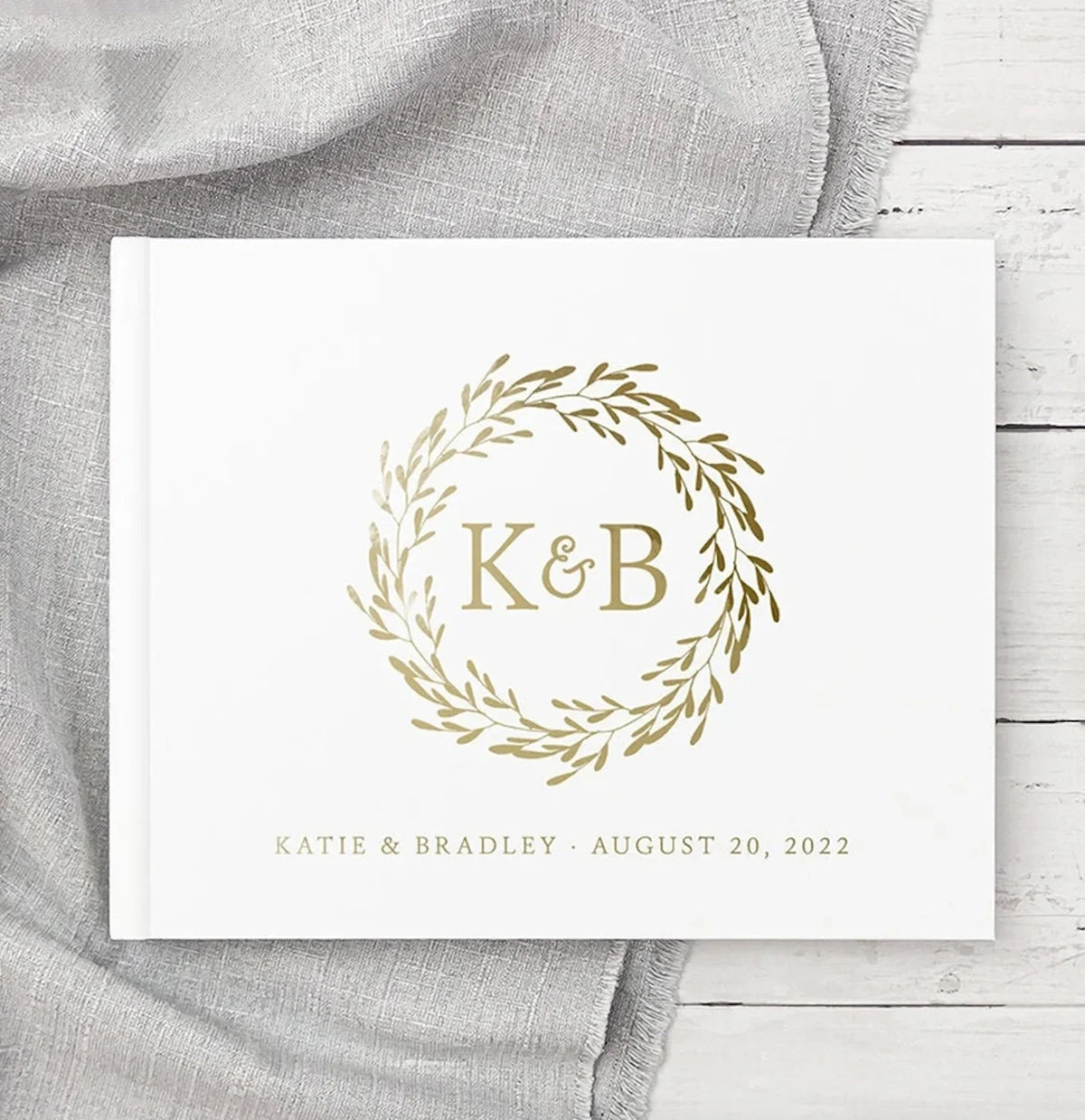 Personalized wedding guest book with gold monogram "K&B" in wreath and Aug 20, 2022