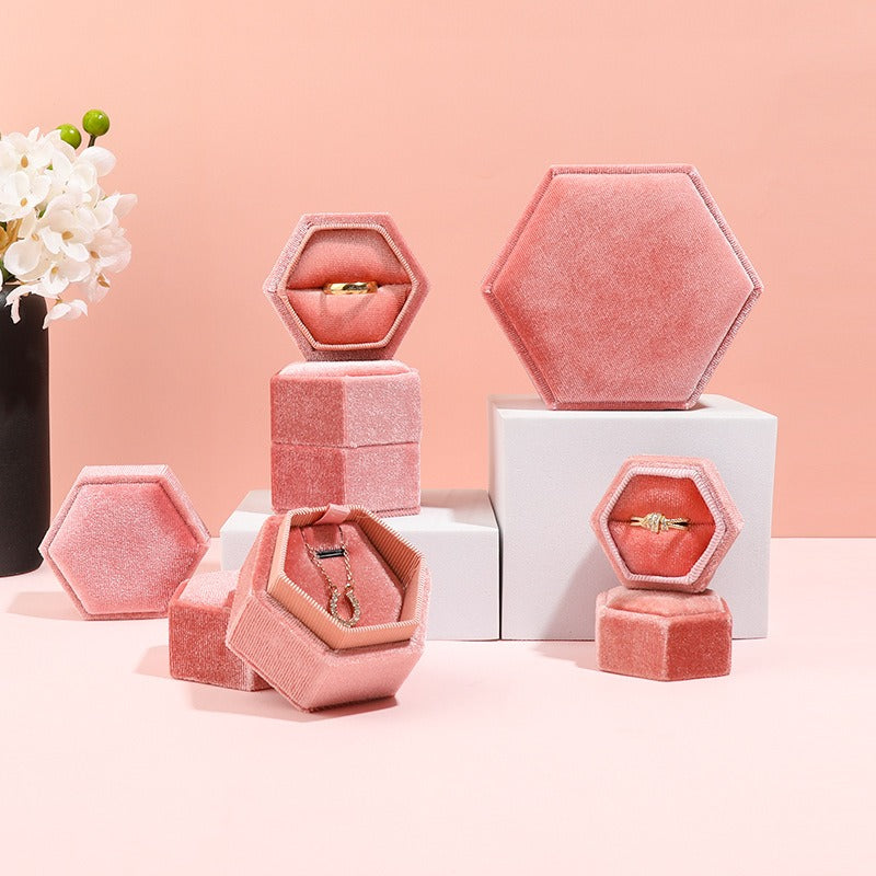 Hexagonal velvet jewelry box set in pink with open compartments for rings and pendants