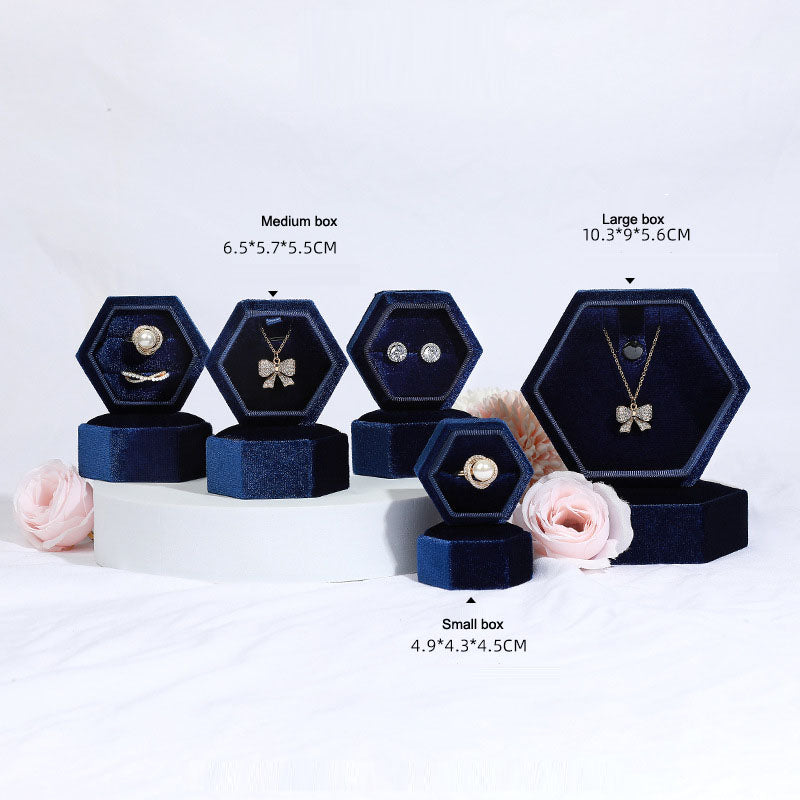 Hexagonal velvet jewelry box set in navy blue with open hex compartments for rings and necklaces