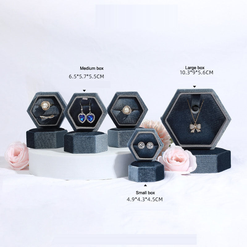 Hexagonal velvet jewelry box set in dark blue with open hex compartments for rings and necklaces