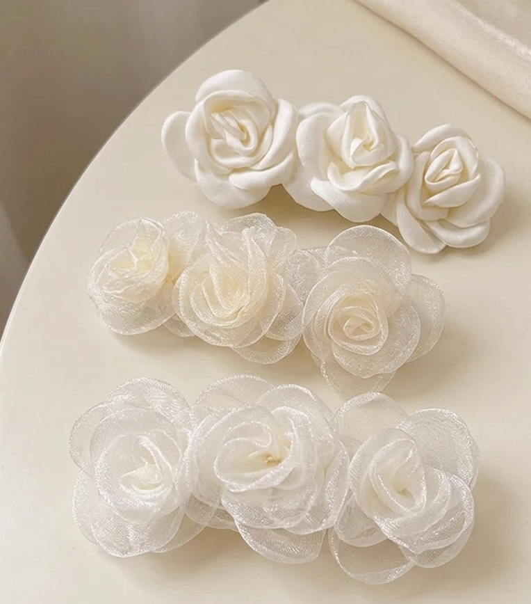 Off-white satin rose clip-on barrette with three fabric rosettes.