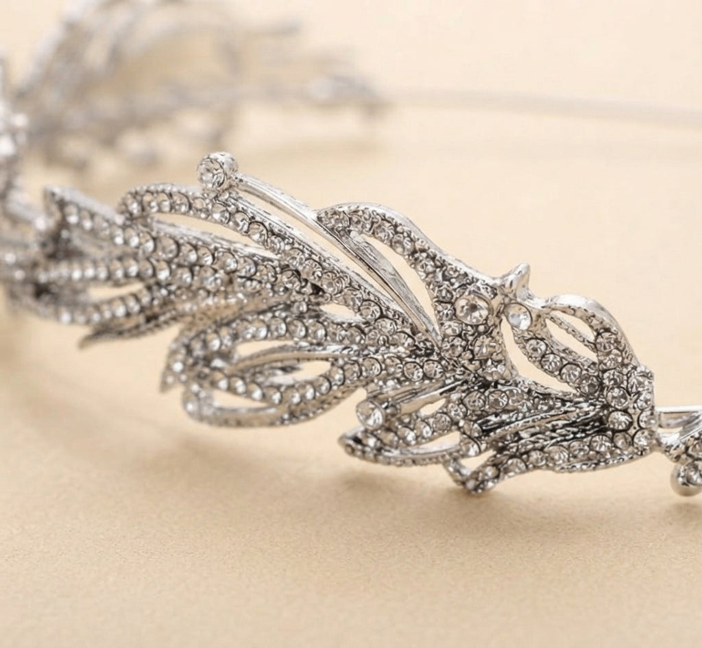 Close-up bridal headband with crystal leaf and swirl details, metal band prongs