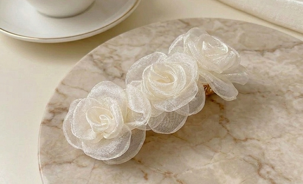 Champagne satin rose clip-on barrette with three rosettes, angled close-up.