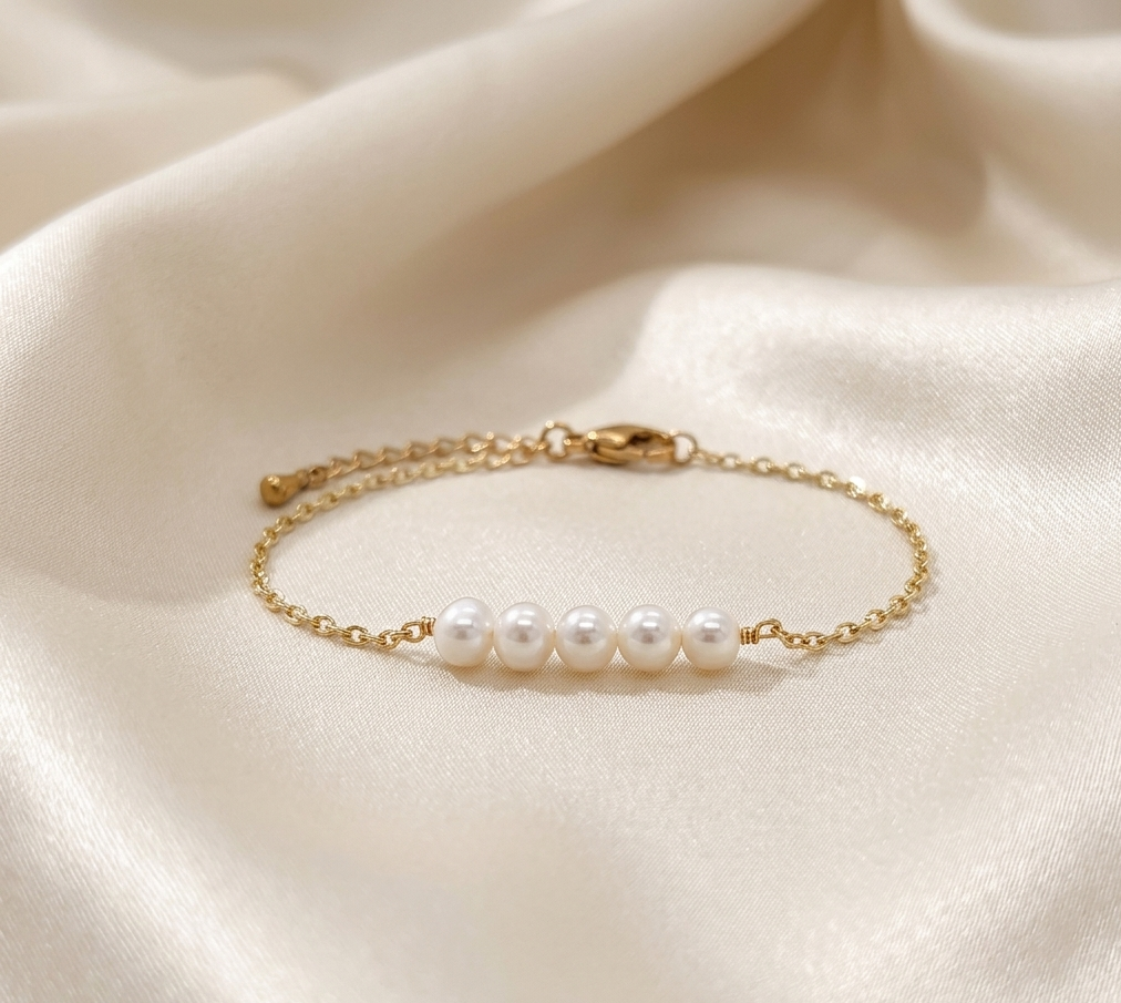 Gold link bracelet with centered row of white pearls and extender chain