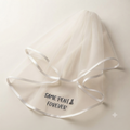 White hen party veil with satin ribbon edges and printed Forever message