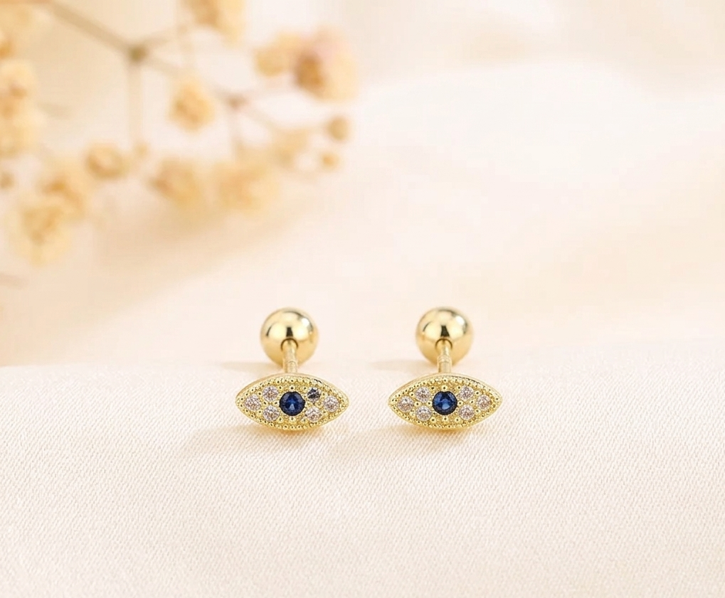 Evil eye huggie hoop earrings with blue crystal accents and gold-tone finish
