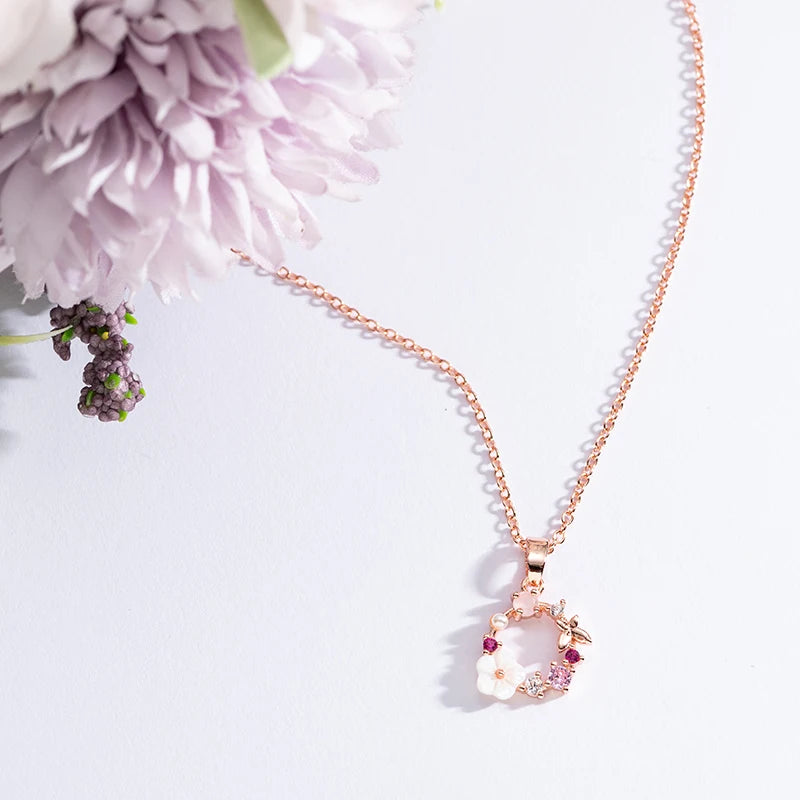 Rose gold floral wreath butterfly pendant necklace with white flowers and purple accents
