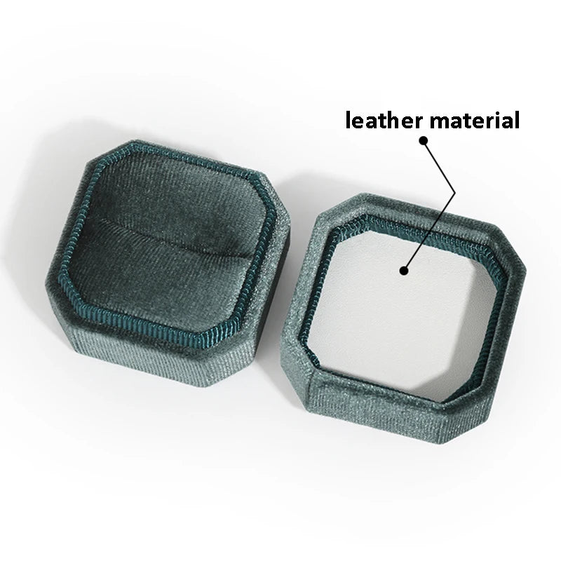 Teal octagonal velvet ring box, open lid view; label indicates leather material