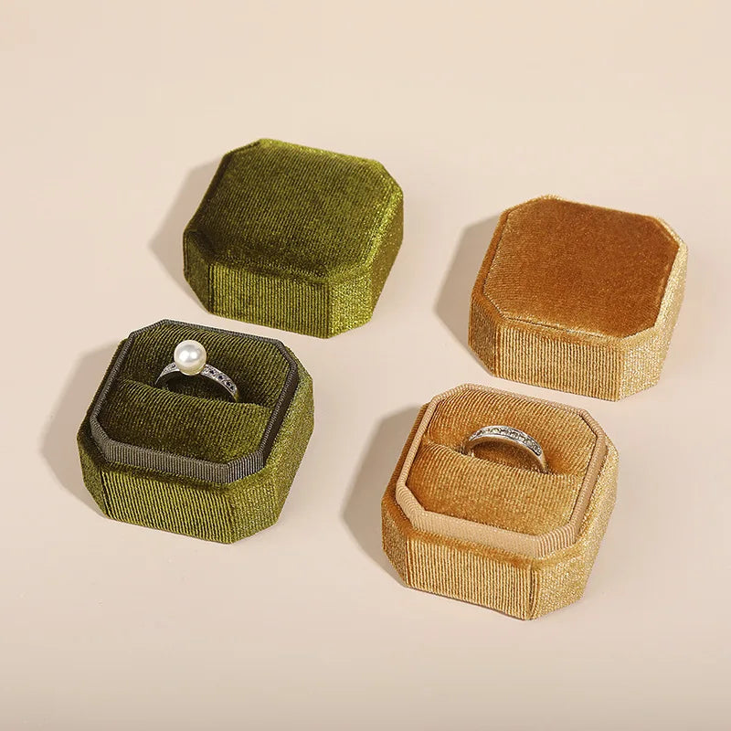 Octagonal velvet ring boxes in olive and tan, open lid view with ring inside