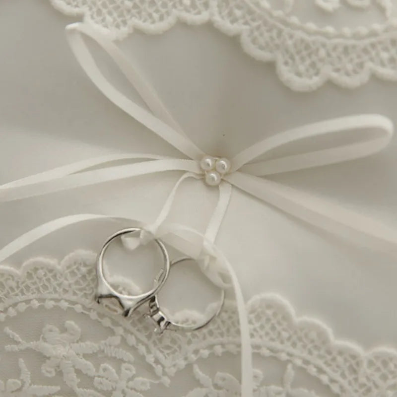 White satin ribbon bow with pearl accents and metal ring holder