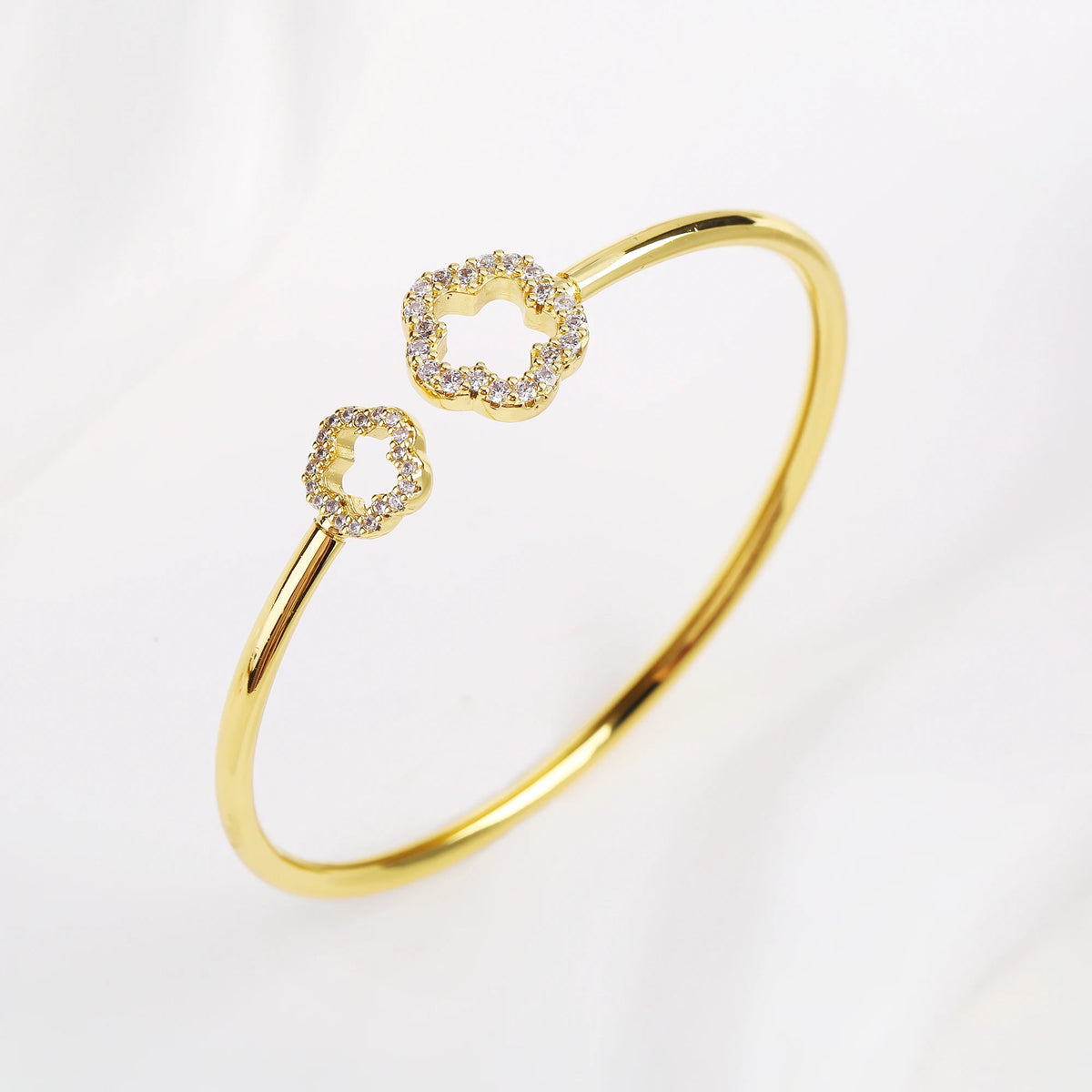 Gold open cuff bangle with zirconia clover accents