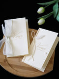 Ivory wedding vows booklet set with white ribbon ties and gold-toned lettering