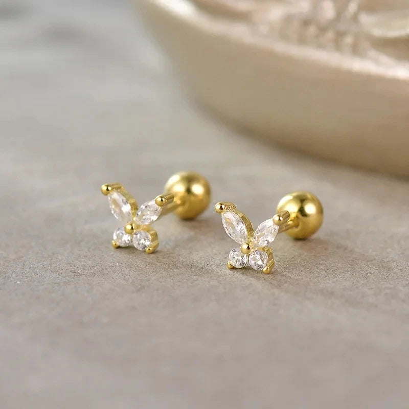 Gold-tone stud earrings with four-petal flower design and clear stone centers