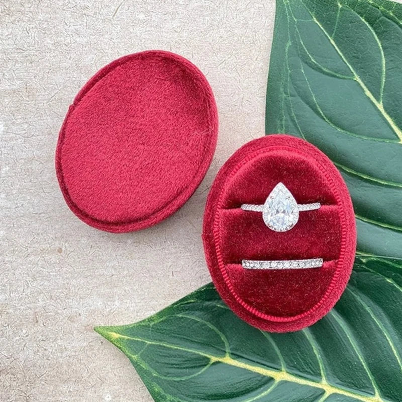 Red velvet ring box with diamond-style ring and slim silver band