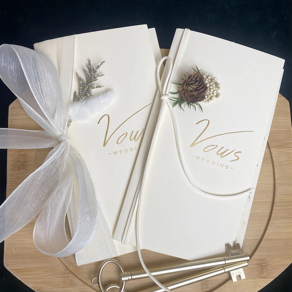 Ivory vows booklet set with gold-foil “Vows” lettering, tied ribbons and matching keepsake keys