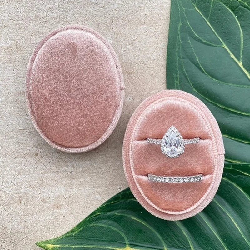 Soft pink velvet ring box with oval gemstone ring and slim sparkling band