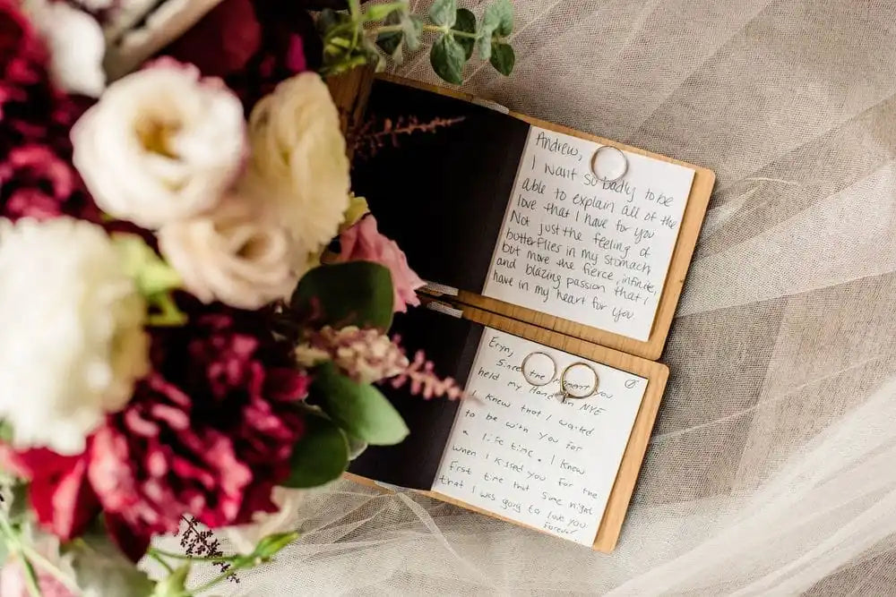 Open wooden wedding vow book set with handwritten pages and printed portrait