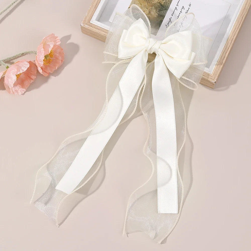 Cream chiffon bow hair clip with long ribbon streamers and sheer tails