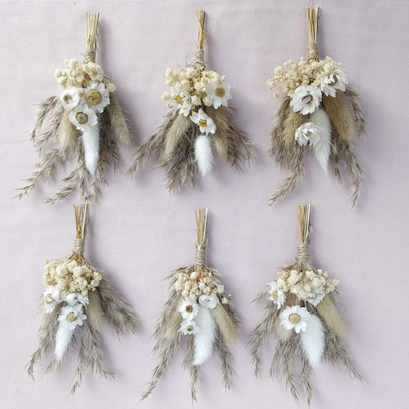 Collection of dried flower boutonnieres with cream blossoms, tan pampas plumes, and gold stems