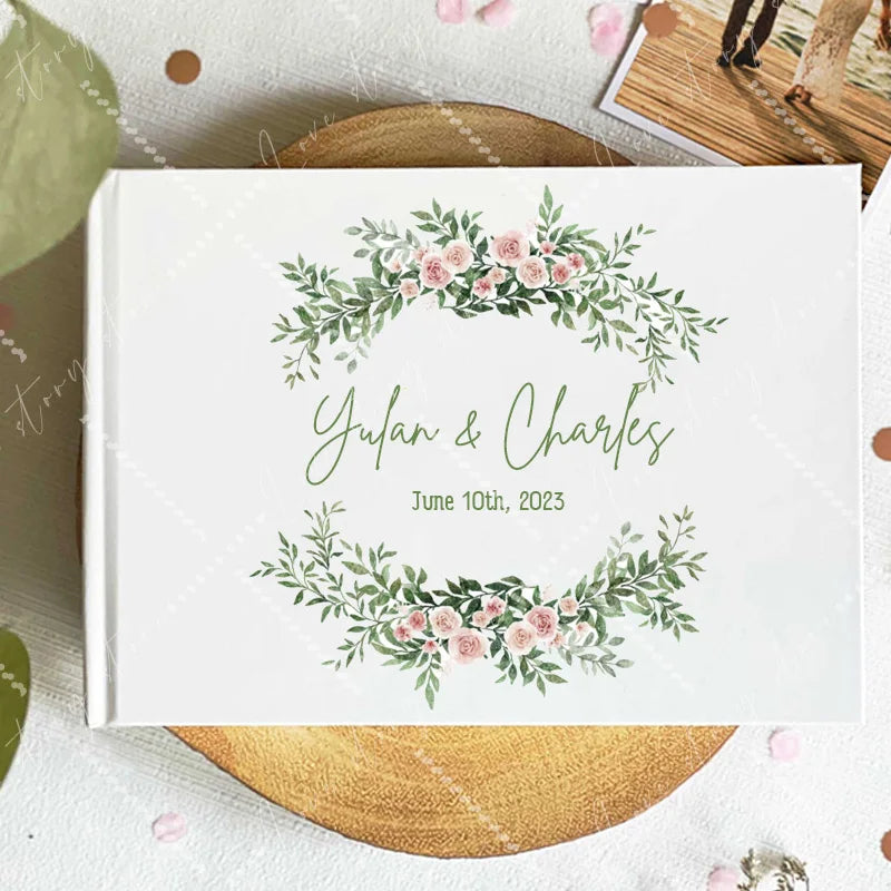 Wedding guest book cover with green eucalyptus wreath and pink roses; names and date June 10, 2023