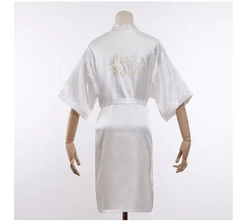 White satin robe with embroidered “Maid of Honor” on back and tied waist belt