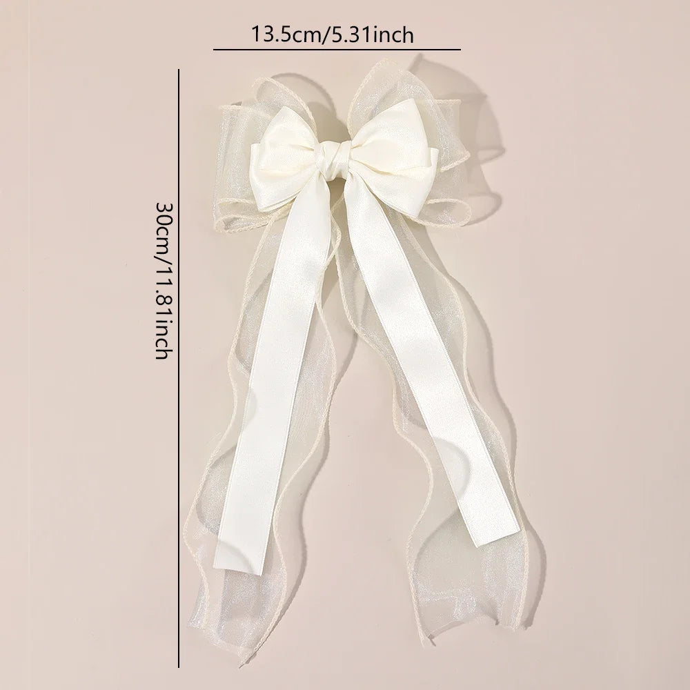 White chiffon bow hair clip with long trailing ribbon tails and layered tulle