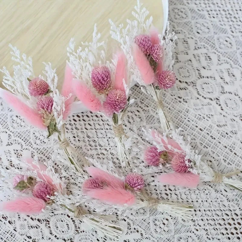 Set of dried flower boutonnieres with pink buds, white feathery stems, and lace texture