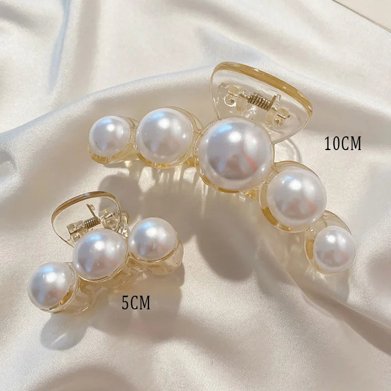 Pearl claw hair clip with gold-tone frame and white faux pearls; ~10cm.