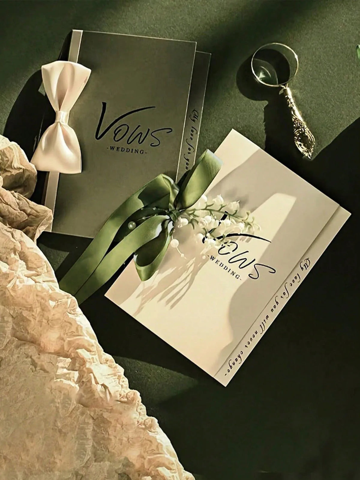 Wedding vow booklet keepsake with white ribbon bow, pearl chain, and green accent bow
