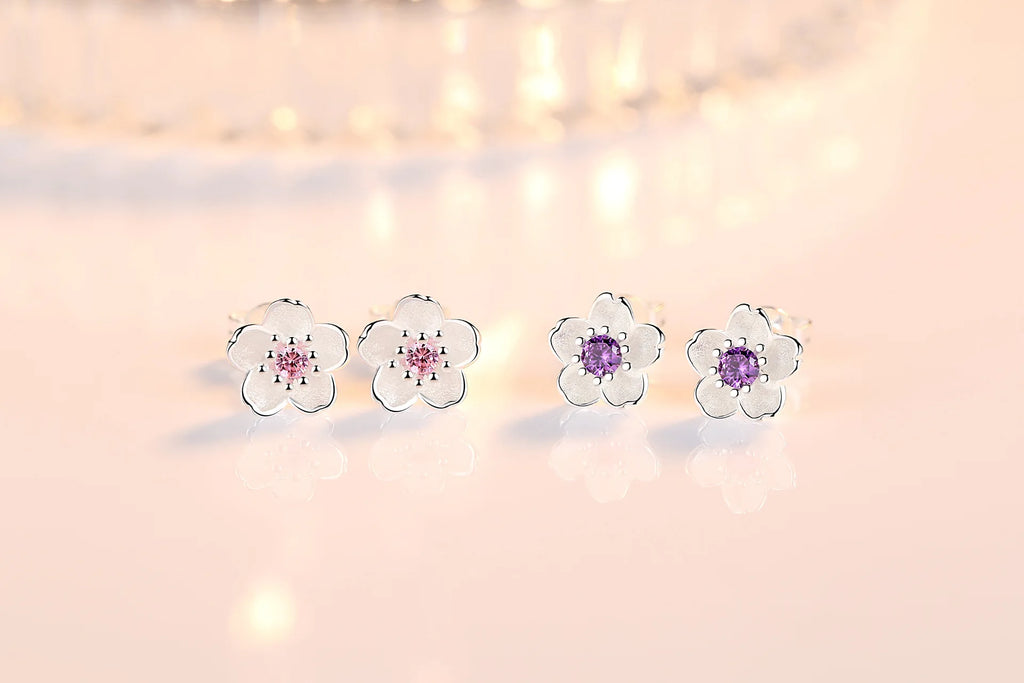 Flower stud earrings display with pink and purple zircon center stones in silver-tone settings