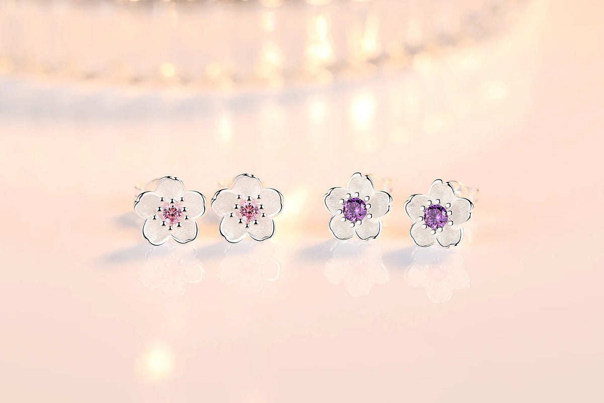Flower stud earrings display with pink and purple zircon center stones in silver-tone settings