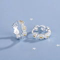 Silver-tone huggie hoop earrings with daisy and small gold accents