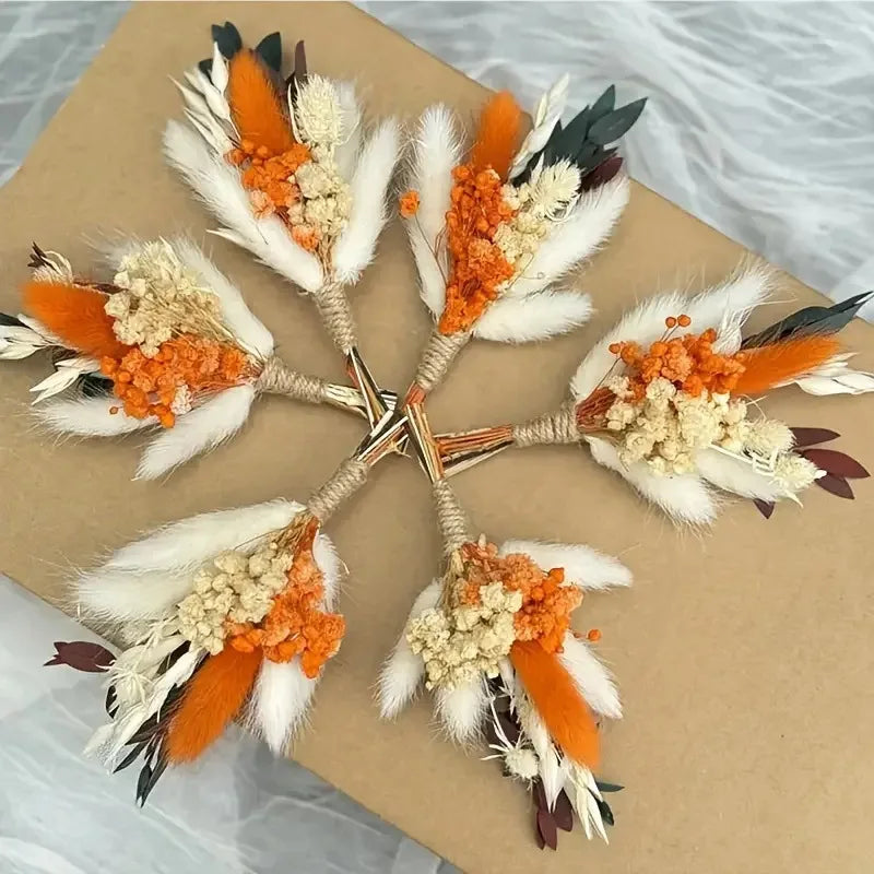 Set of 6 dried flower boutonnieres with orange blooms, white feather accents, and greenery