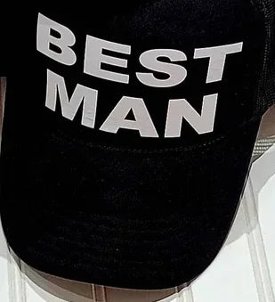 Black mesh trucker cap with bold white text: BEST MAN