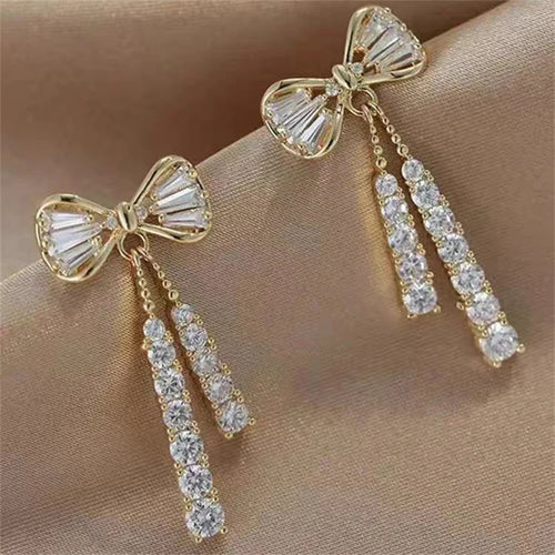 Gold-tone bow stud earrings with dangling crystal tassel drops