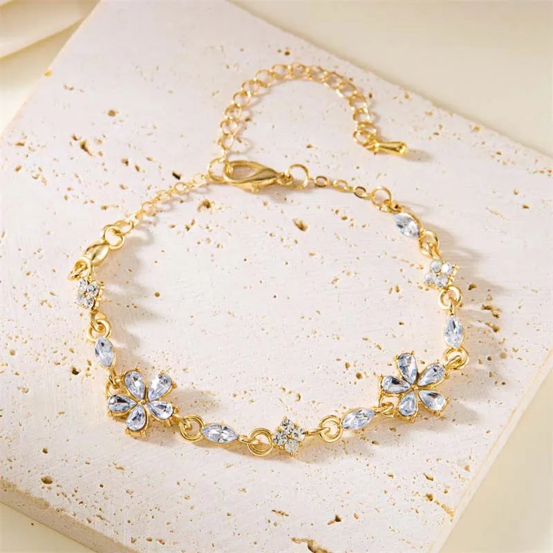 Gold-tone crystal flower bracelet with blue-clear petal charms