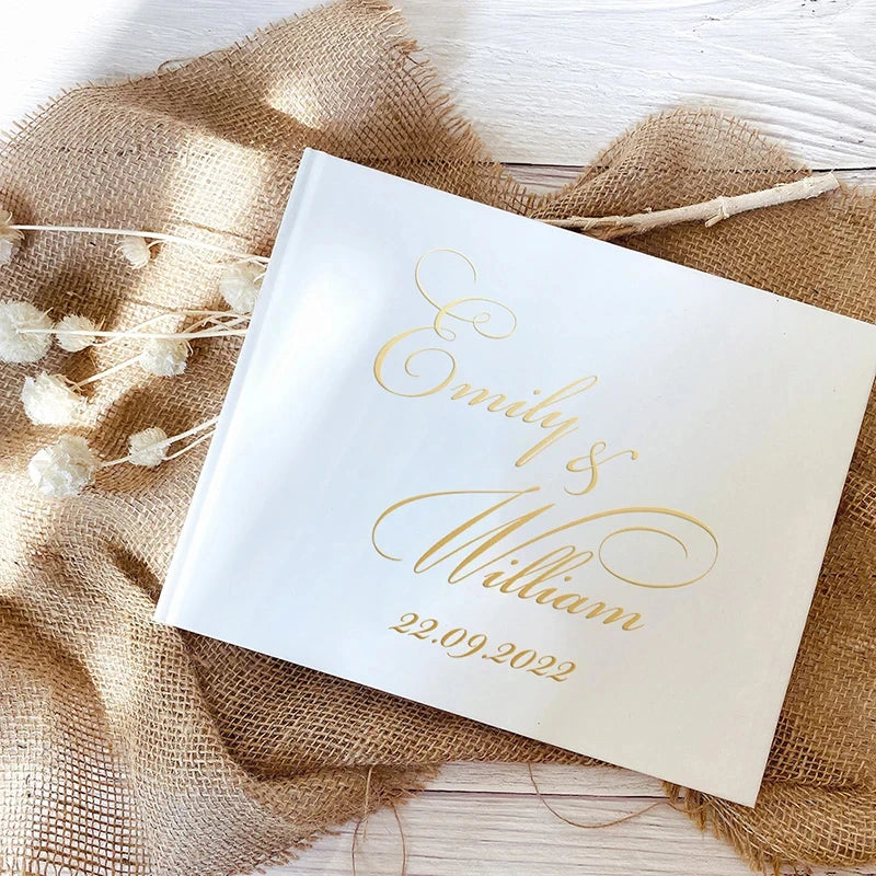 Personalized wedding guest book with gold script "Emilie + William" and 22.09.2022