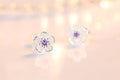 Silver-tone flower stud earrings with purple zircon center and clear outer stones