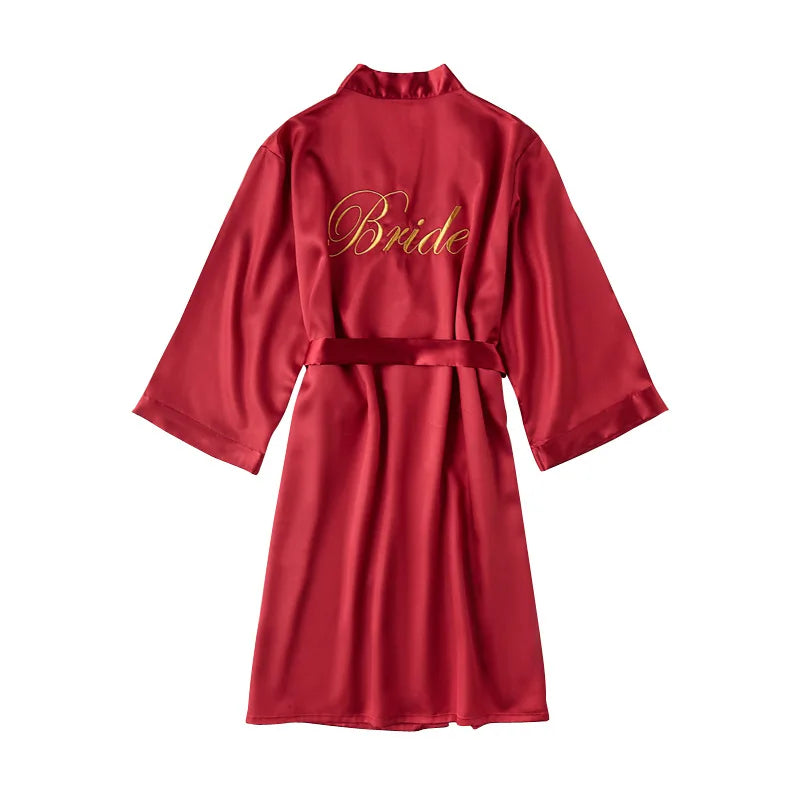 Red satin robe with embroidered “Bride” on chest and a tied waist belt