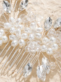 Bridal hair comb close-up with ivory pearls, faceted crystals, and fine comb tines